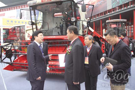 雷沃重工执行副总经理王玉荣（左一）向中国农机工业协会会长陈志（左二）一行介绍公司参展情况