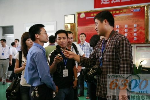 采访团记者深入工厂一线采访党员代表（前左）