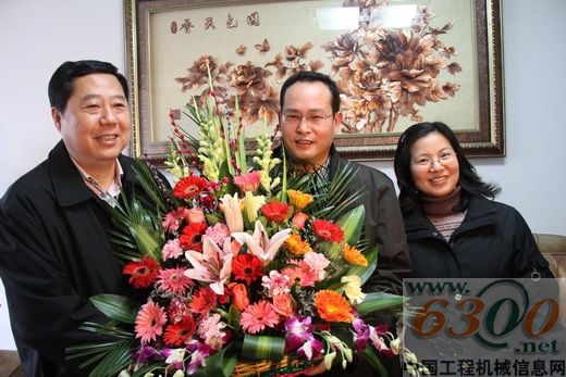 韩元利(左)向胡国强夫妇送上慰问花篮