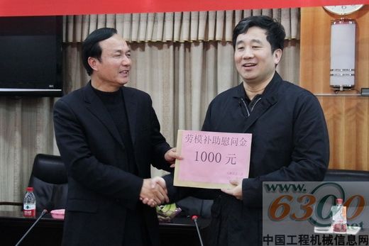 刘子福(左)向全国劳模晏平颁发慰问金