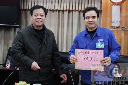 张福文(左)向全国劳模林杰军颁发慰问金