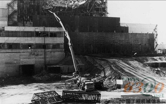 1986年普茨迈斯特长臂架混凝土泵车在前苏联切尔诺贝利核电抢险，通过在几百米外远的固定式混凝土泵上料，或者如图示直接由搅拌车上料